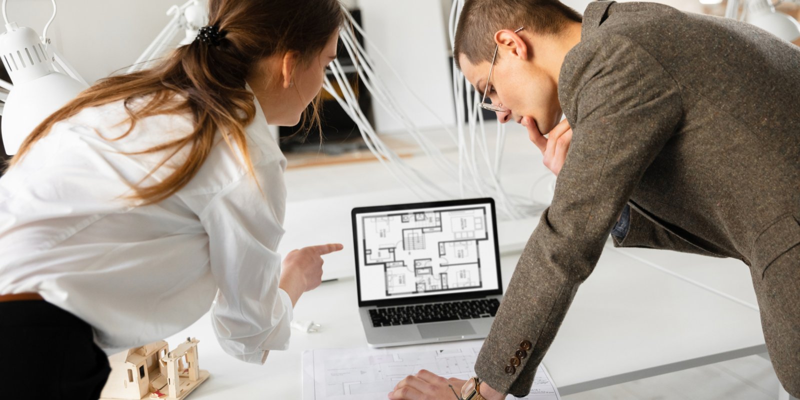 Details. Female estate agent showing new home to a young man after a discussion on house plans. Choosing construction materials, repair, technologies in smart house. Moving, new home concept.