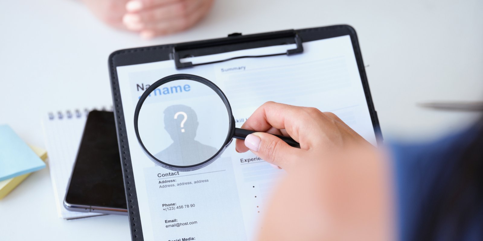 Employer looking at worker resume with magnifying glass closeup. Recruitment concept